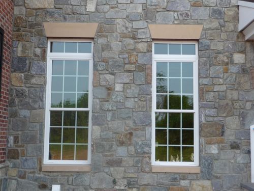 Exterior gray stone wall of home with windows