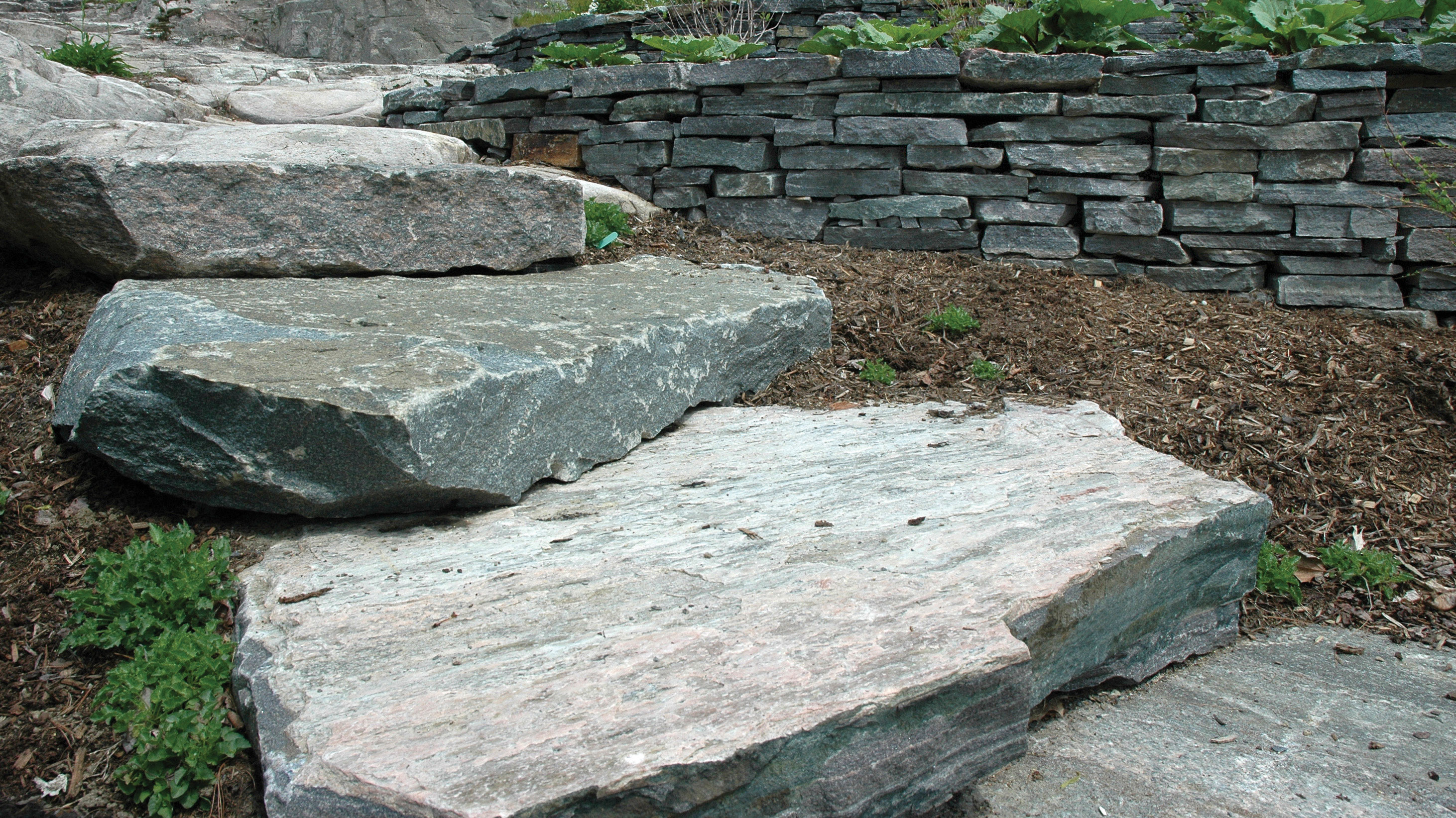 1 Solid stone steps in front of mulch and decorative stone wall