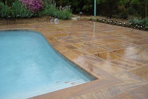 Orange and brown outdoor pavers next to large pool