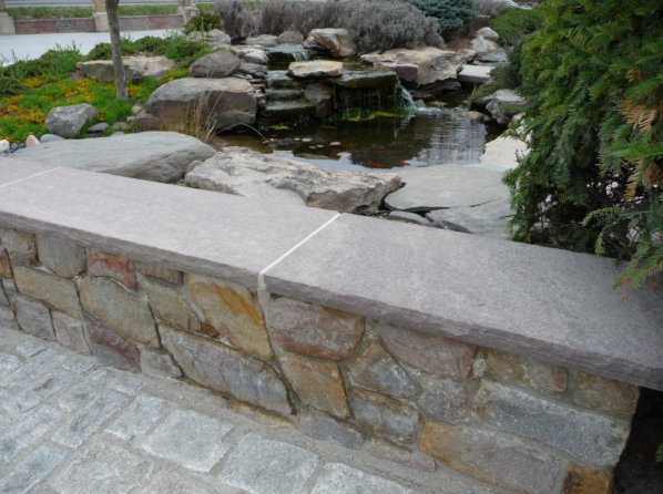 Decorative outdoor stone wall overlooking stone water feature