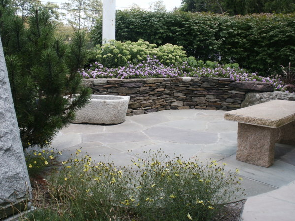 Outdoor patio with decorative stone wall and greenery
