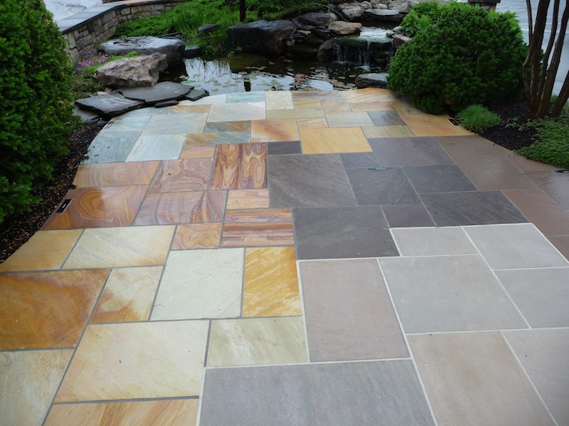 Pennsylvania Flagstone pavers next to greenery and outdoor stone water feature