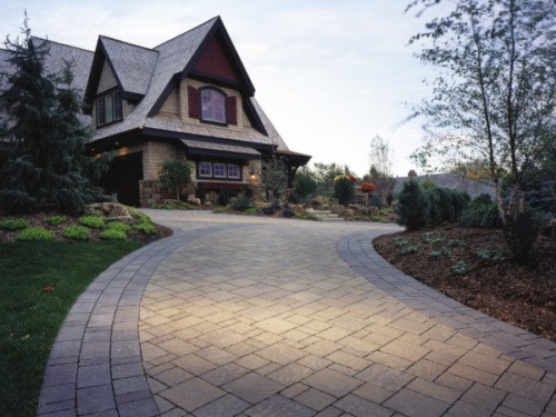 Stone paved driveway leading up to rustic home