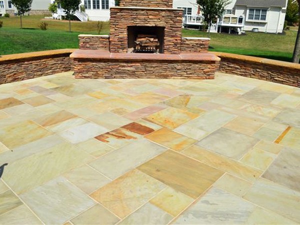 Outdoor stone paved patio and outdoor stone fireplace