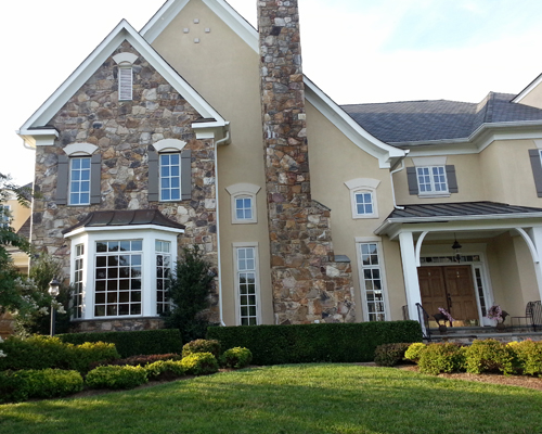 Large beige home with colored stone