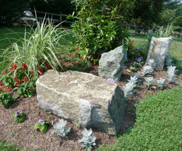 Boulders with flowers in mulch and grass