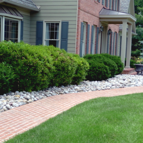 Gravel next to red brick pathway