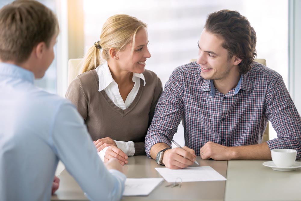 Couple signing documents in an office